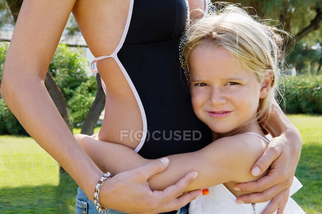 Primer plano de un niño abrazando a su madre - foto de stock