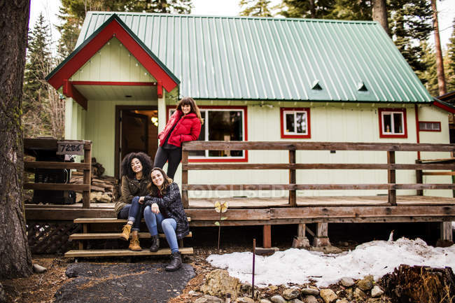 Portrait of three friends in front of cabin — Stock Photo