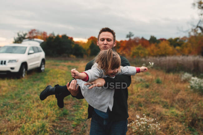 Homme adulte moyen jouant avec la fille tout-petit dans le champ — Photo de stock