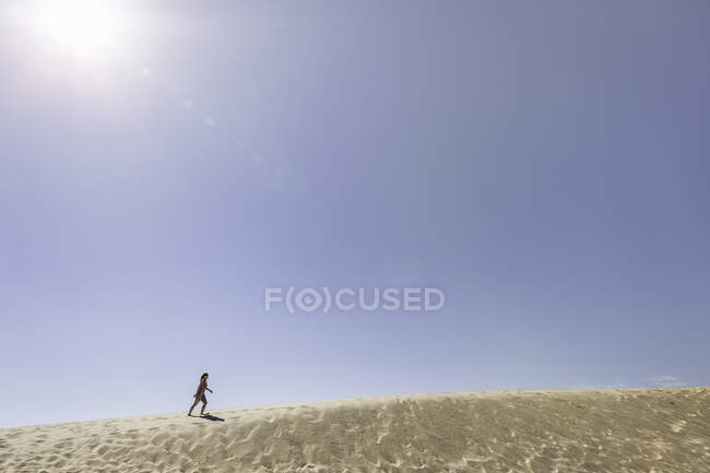 Mujer joven corriendo hasta Dune de Pilat, Francia - foto de stock