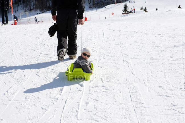 Father pulling son on sledge — Stock Photo