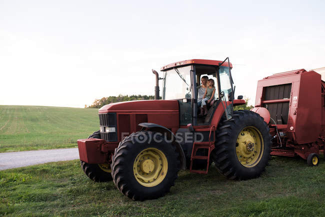 Мати і дочка сидять у тракторі — стокове фото