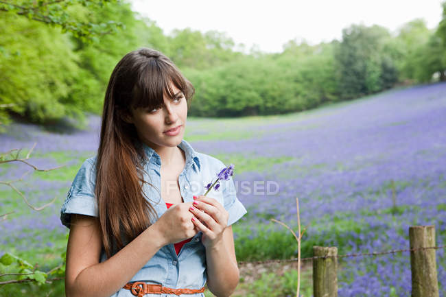 Jeune femme avec fleur de bluebell — Photo de stock