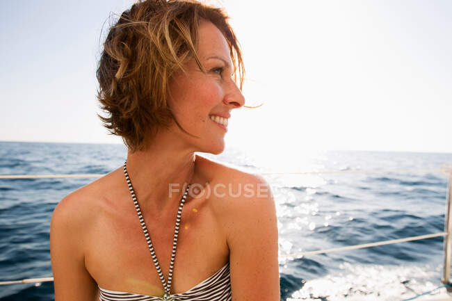 Улыбающаяся женщина в бикини на лодке — стоковое фото