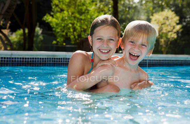 Mädchen und Junge im Schwimmbad — Stockfoto