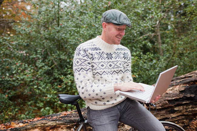 Homem ao ar livre com laptop e bicicleta — Fotografia de Stock