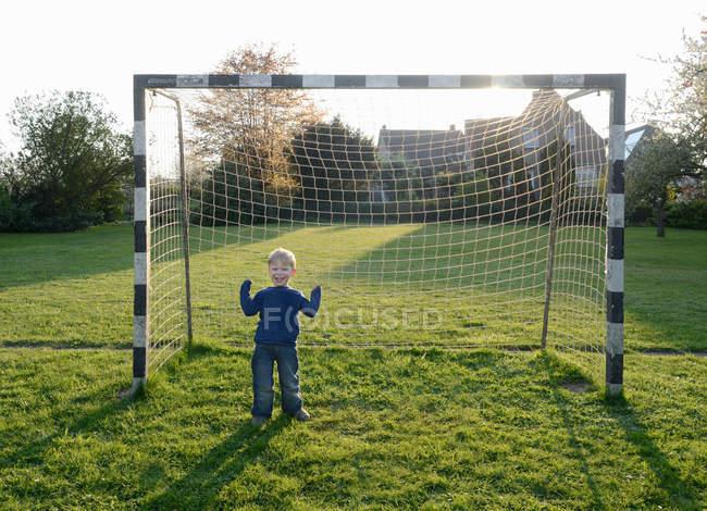 Мальчик аплодирует на футбольном поле — стоковое фото