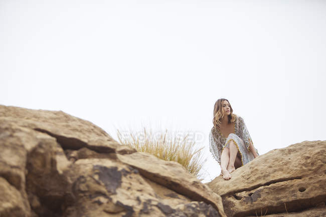 Женщина, отдыхающая на скальной формации, Стоуни Пойнт, Топанга Каньон, Чэворт, Лос-Анджелес, Калифорния, США — стоковое фото