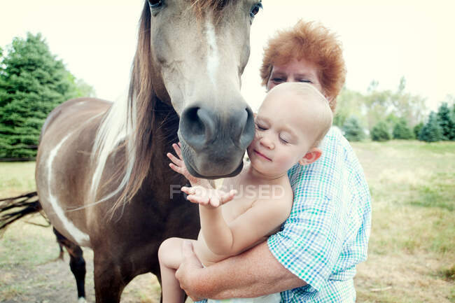 Avó e criança com cavalo — Fotografia de Stock