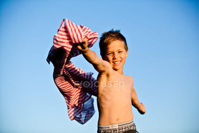 Boy playing with striped fabric — Stock Photo