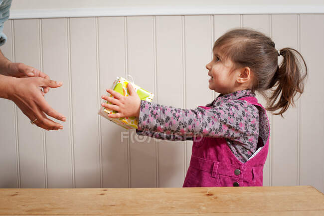 Petite fille donnant un cadeau à un adulte — Photo de stock
