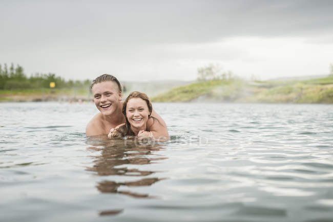 Parejas jóvenes en Secret Lagoon hot spring (Gamla Laugin), Fludir, Islandia - foto de stock