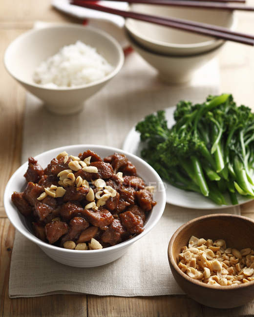 Bowl of thai style pork with broccolini, peanuts and rice — Stock Photo