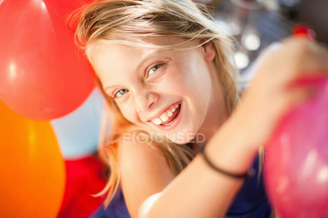 Sorrindo menina segurando balão na festa — Fotografia de Stock