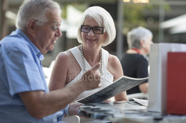 Ciudad del Cabo Sudáfrica, Eldery macho y hembra en el restraunt pasando por el menú - foto de stock