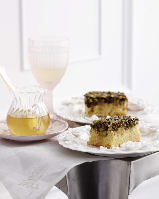 Porções de bolo de pistache com copo de chá — Fotografia de Stock