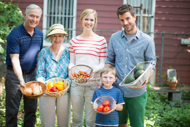 Three generation family with homegrown vegetables — Stock Photo