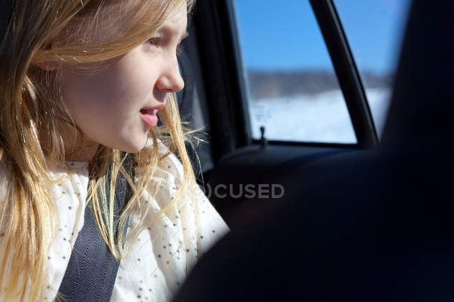 Jeune fille regardant par la fenêtre de la voiture — Photo de stock