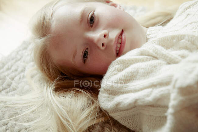 Молодая девушка лежит на спине, улыбаясь — стоковое фото