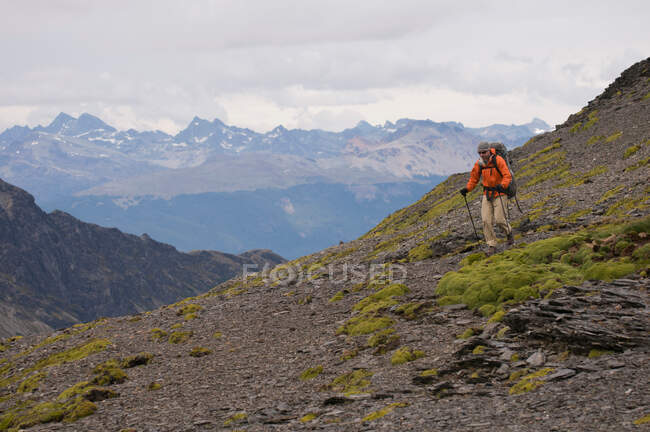 Caminhante andando com paus em colinas rochosas — Fotografia de Stock