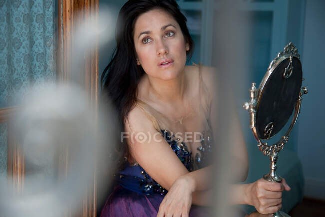 Donna che tiene lo specchio, distogliendo lo sguardo — Foto stock