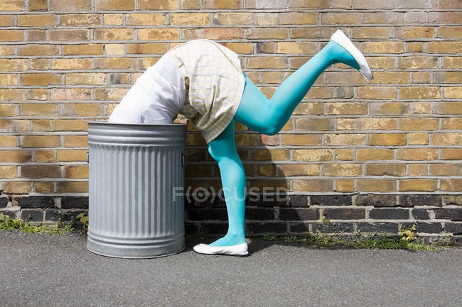 Обрезанное изображение женщины, смотрящей в мусорный бак — стоковое фото