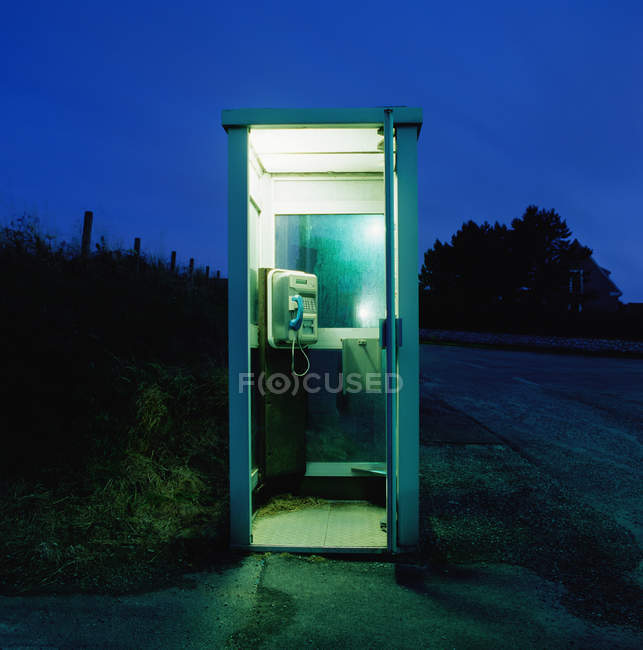 Empty Telephone booth outdoors at nighttime — Stock Photo