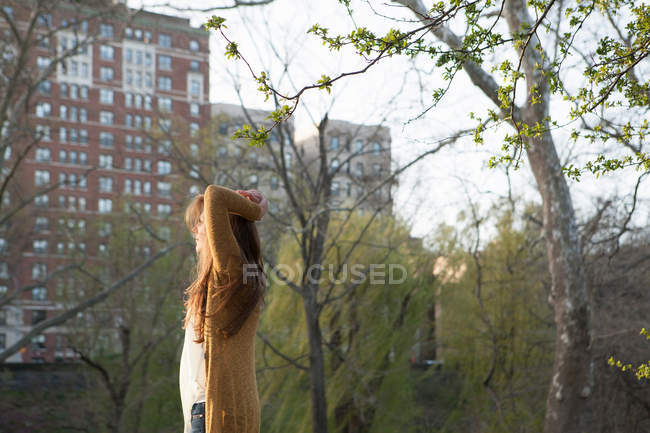 Junge Frau steht im Park — Stockfoto
