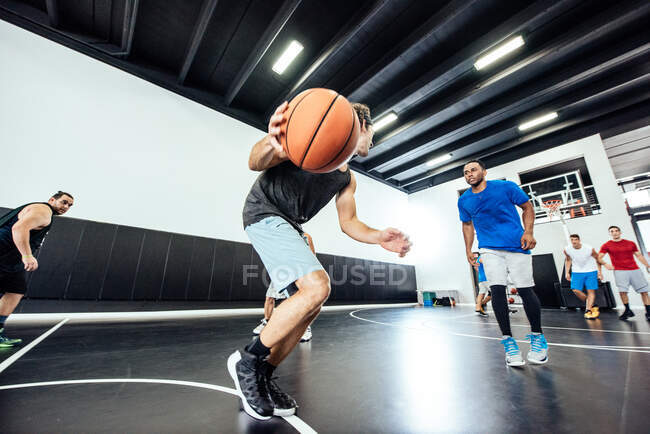Чоловічий баскетболіст біжить з м'ячем на баскетбольному майданчику — стокове фото