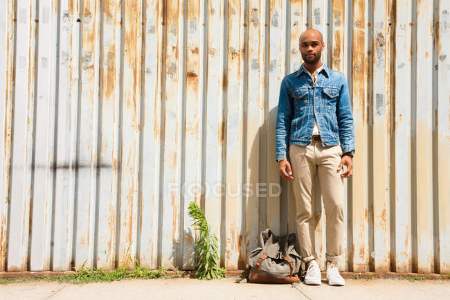 Портрет молодого человека перед гофрированным забором — стоковое фото