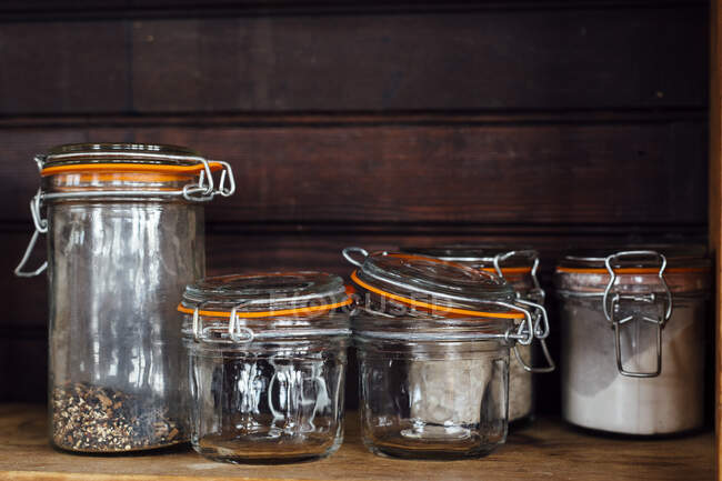 Vaso di vetro con spezie ed erbe su fondo di legno. focus selettivo. — Foto stock