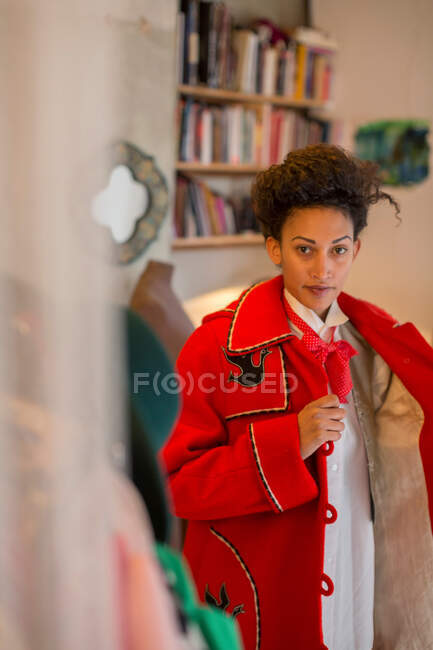 Portrait of Woman putting on coat — Stock Photo