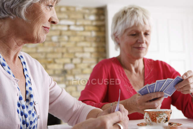 Seniorinnen spielen zu Hause Karten — Stockfoto