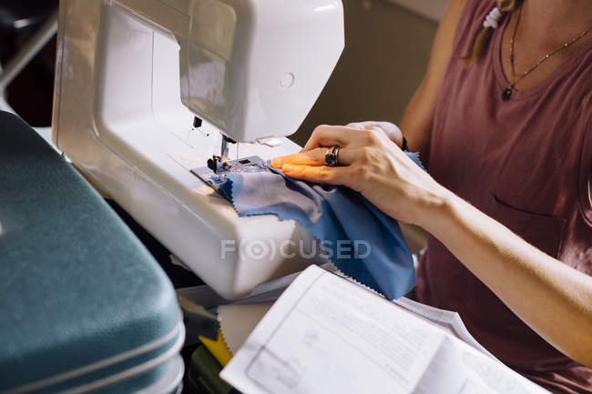 Обрезанный образ женщины, пришивающей швейную машинку — стоковое фото