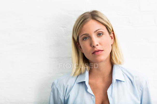 Portrait of beautiful young woman in front of white wall — Stock Photo