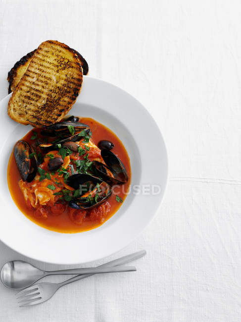 Mussels in soup with bread — Stock Photo