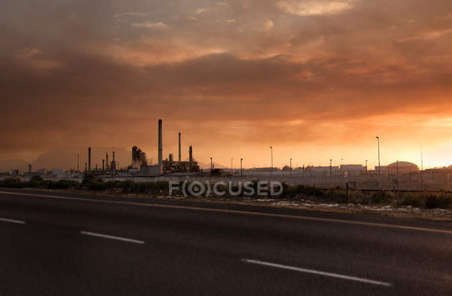 Puesta de sol sobre central eléctrica - foto de stock