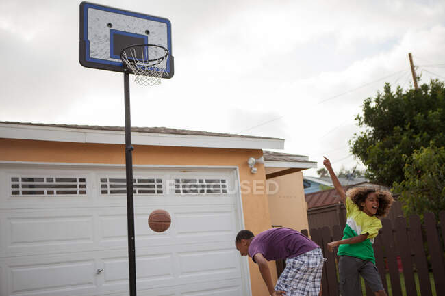 Dos hermanos jugando baloncesto - foto de stock