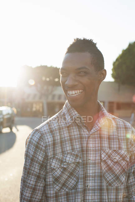 Портрет молодого человека в клетчатой рубашке на улице — стоковое фото