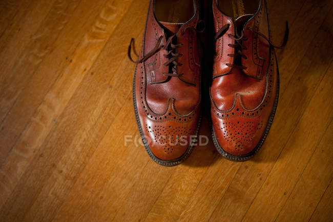 Pair brogue shoes on wooden floor, top view — Stock Photo