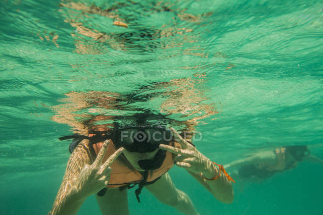 Esnórquel de hombres y mujeres jóvenes, vista submarina, Isla de Nangyuan, Tailandia - foto de stock