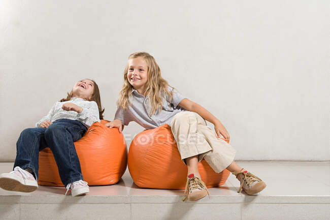 Sorelle seduti su sacchetti di fagioli — Foto stock
