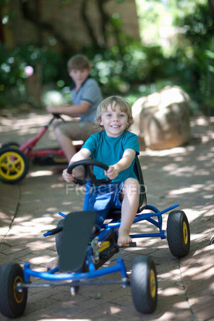 Boys riding go-kart on path — Stock Photo