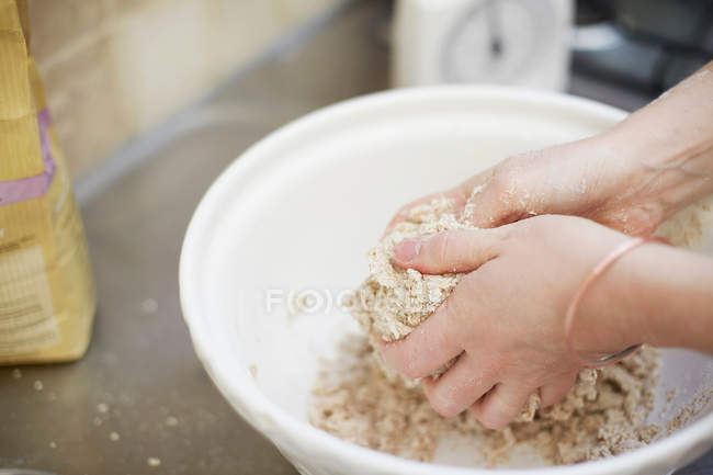 Woman shaping dough in kitchen, cropped shot — Stock Photo