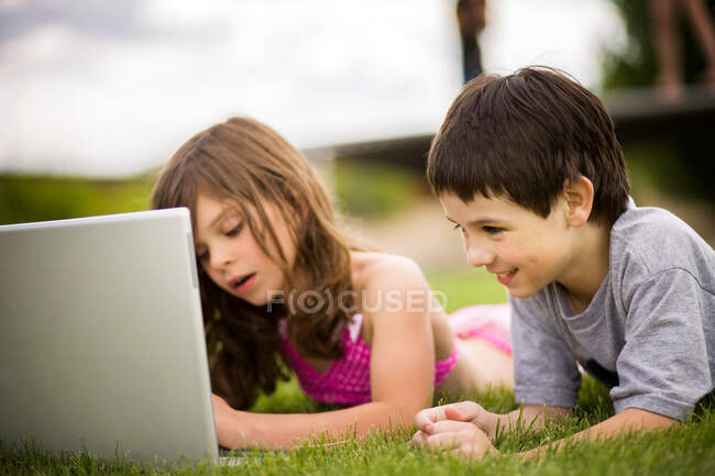 Crianças usando laptop ao ar livre — Fotografia de Stock