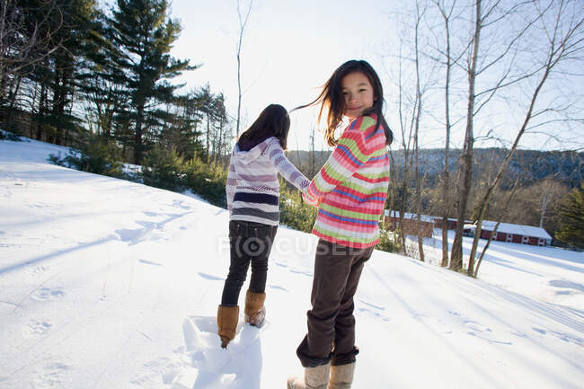 Две девушки идут по снегу — стоковое фото