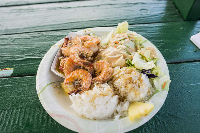 Plate of garlic shrimps and rice on porch — Stock Photo
