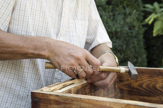 Senior man making wooden crate in garden, mid section — Stock Photo