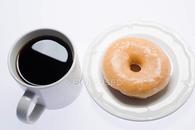 Coffee and doughnut on plate — Stock Photo