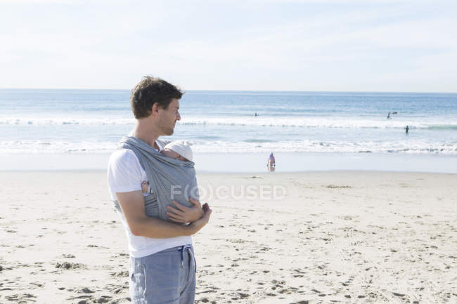 Father holding baby boy on beach — Stock Photo